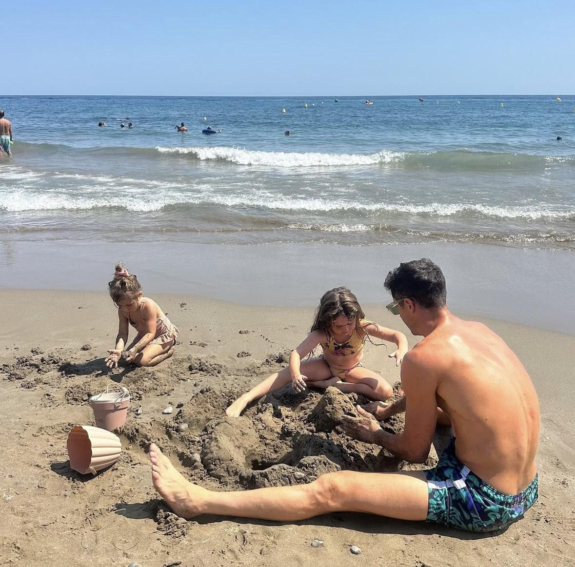 Robert Lewandowski z córkami na plaży robią babki z piasku