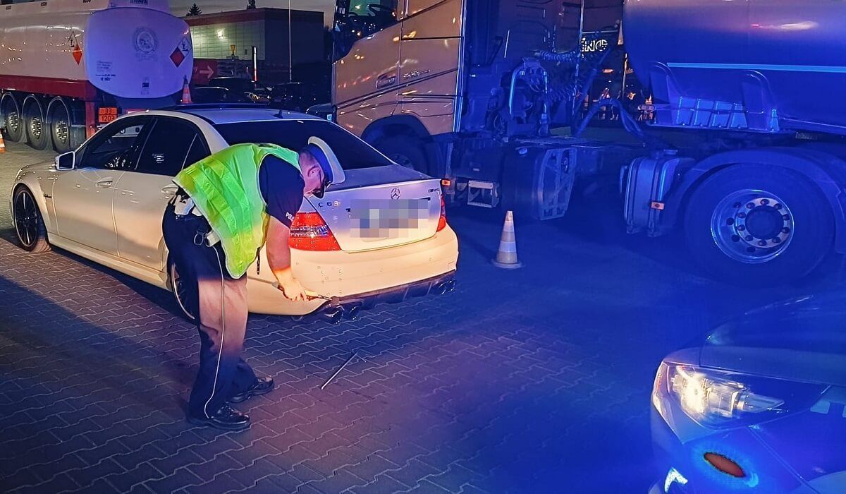 Policjant sprawdza głośność wydechu Mercedesa w ramach akcji "stop-drift"