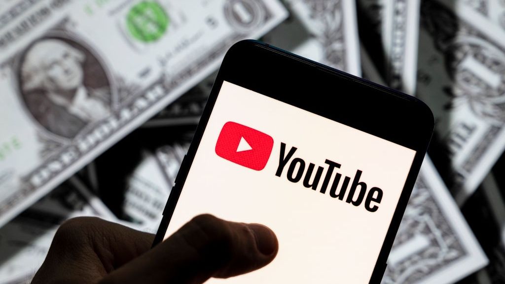 Smartfon z Youtube na tle dolarów