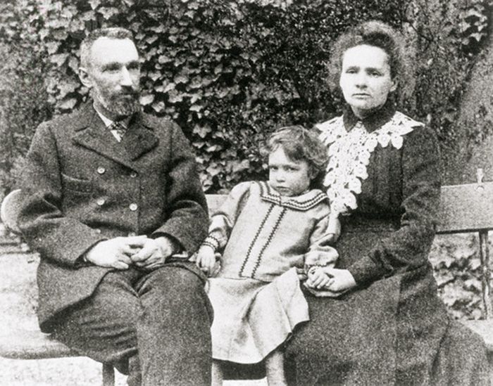 The Curie Family; Marie, Pierre and daughter Irene, sit on an outdoor bench posing for a picture. --- Image by © CORBIS