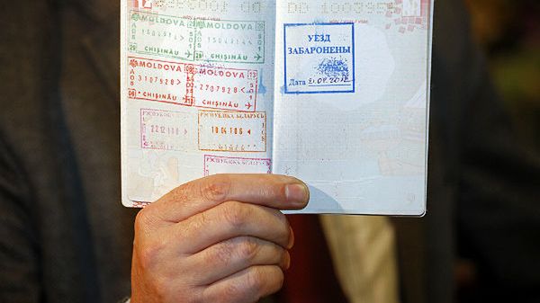 Poseł PiS Adam Lipiński prezentuje paszport z pieczątką zakazu wjazdu na Białoruś