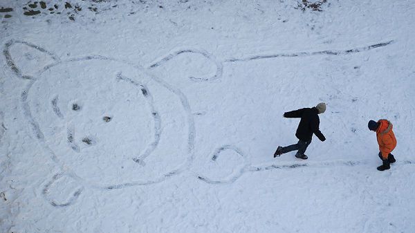 Mimo dużego mrozu dzieci "wydeptują" misia na zaśnieżonym boisku