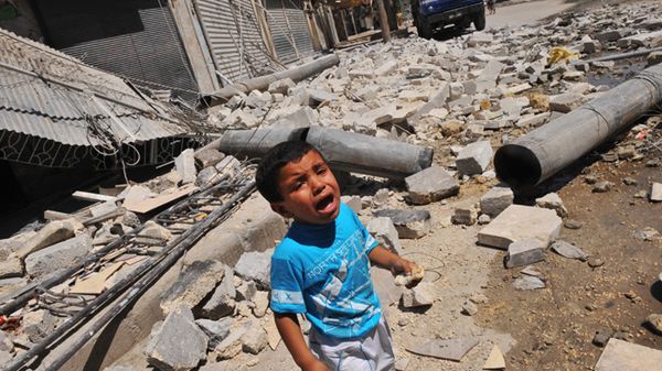Dziecko przy zniszczonym budynku w Aleppo