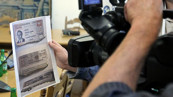 Fotoreporterzy fotografują skan zniszczonego w katastrofie smoleńskiej dowodu osobistego po wiceministrze Kultury Tomaszu Mercie