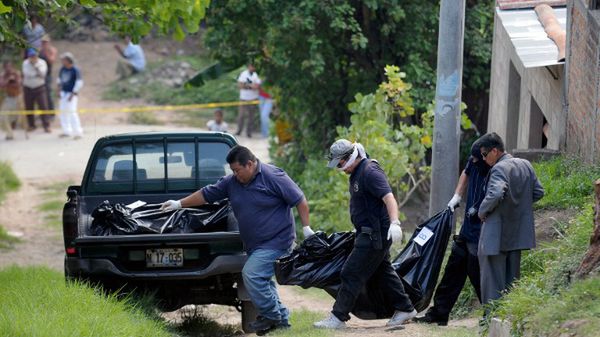 Policyjni śledczy zabiera ciała dwóch nastolatek i dwóch dorosłych kobiet zabitych prawdopodobnie przez członków gangu