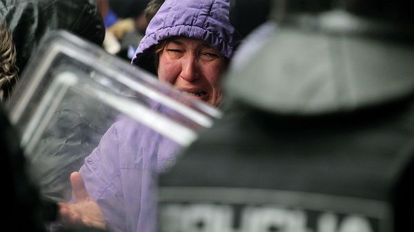 Kobieta płacze przed policjantami w trakcie protestów w Sarajewie