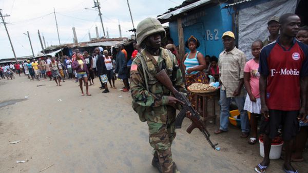 Liberyjski żołnierz patroluje slumsy West Point w Monrowii