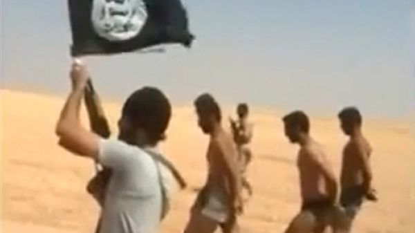 Kadr z nagrania opublikowanego przez dżihadystów - członek Państwa Islamskiego prowadzi jeńców