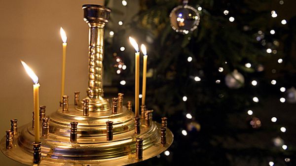 Płonące świece obok przystrojonej choinki podczas liturgii tzw. "Wełykiego poweczeria" w wigilijny wieczór w soborze archikatedralnym w Przemyślu.
