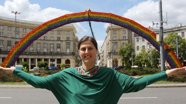 Julita Wójcik na tle tęczy na Pl. Zbawiciela