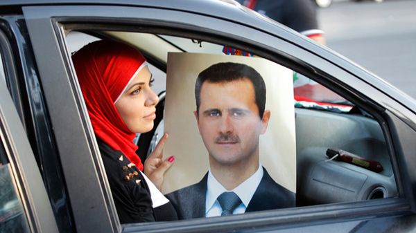 Syryjka z portretem Baszara al-Asada