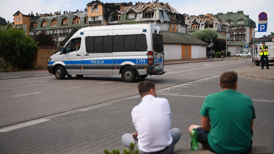 Mieszkańcy przed spalonym domem w Ząbkach