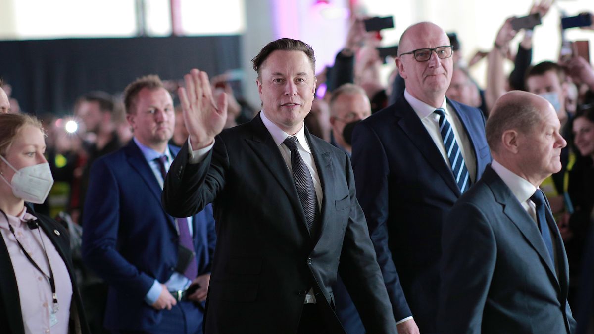 GRUENHEIDE, GERMANY - MARCH 22: German Chancellor Olaf Scholz (R), Brandenburg State Premier Dietmar Woidke (2ndR) and Tesla CEO Elon Musk (C) attend the official opening of the new Tesla electric car manufacturing plant on March 22, 2022 near Gruenheide, Germany. The new plant, officially called the Gigafactory Berlin-Brandenburg, is producing the Model Y as well as electric car batteries. (Photo by Christian Marquardt - Pool/Getty Images)
