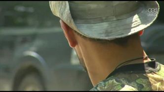 Prorosyjski bojownik pilnuje zniszczonego ukraińskiego czołgu