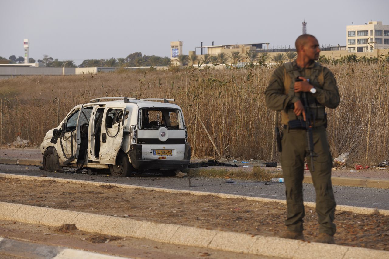 An Israeli soldier beside a vehicle hit by a rocket fired by Hamas militants in Netivot, Israel, on Sunday, Oct. 22, 2023. Be'eri is one of a dozen communities around the Gaza Strip, along with several military bases, that fell prey to the shock invasion by Hamas  which is designated a terrorist organization by the US and European Union - on Oct. 7. Photographer: Kobi Wolf/Bloomberg via Getty Images
