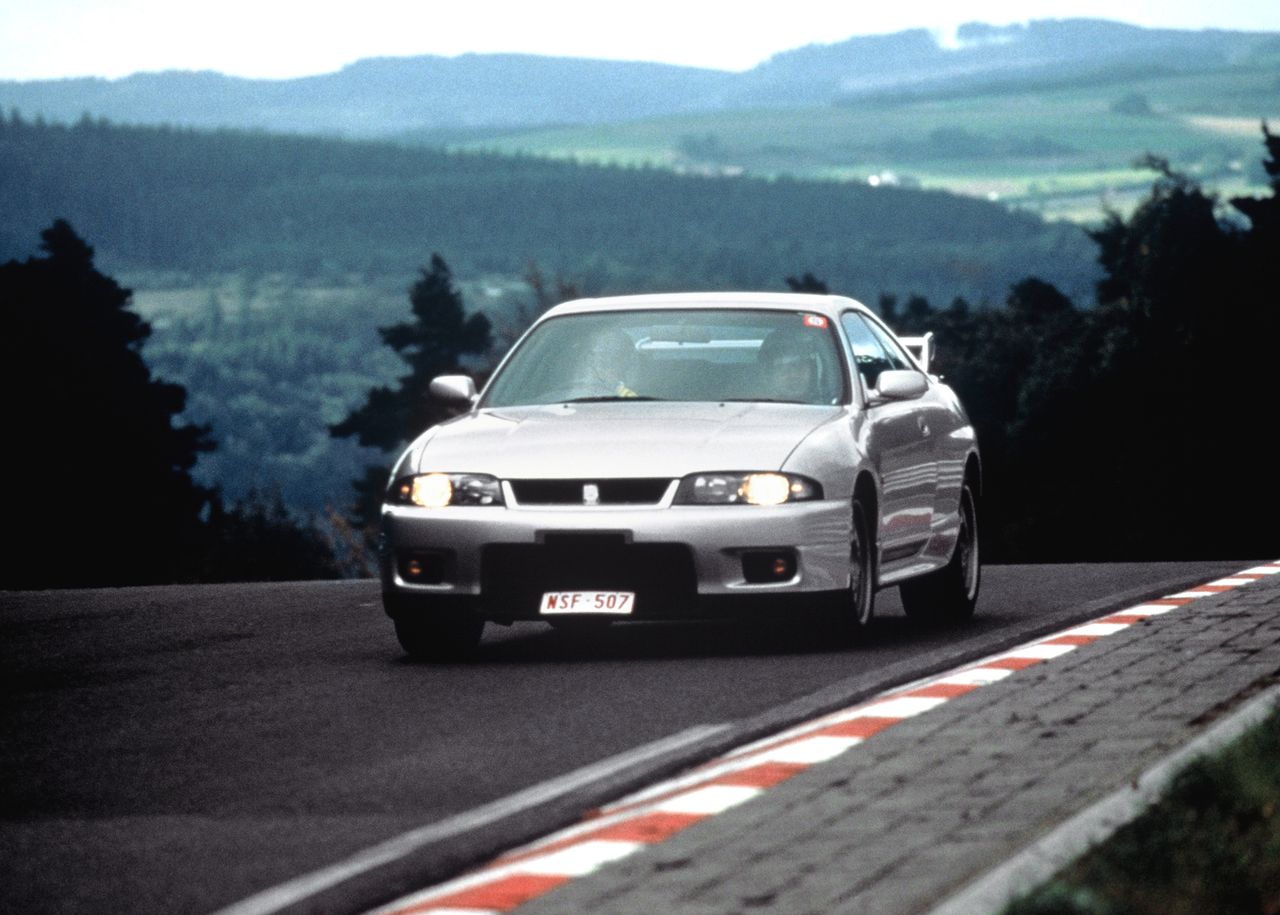 Produkowany od 1993 roku Skyline GT-R R33 był godnym następcą Godzilli, ale nie w wyścigach. Ta generacja nie była stworzona z myślą o japońskich seriach lecz z myślą o podbiciu rynków USA i brytyjskiego. By zaprezentować się z dobrej strony, musiał zaimponować na Nürburgringu. Jego poprzednik uzyskał na Północnej Pętli fenomenalny czas 8:22 min, ale R33 szczycił się zbliżeniem do 8 minut z czasem 8:01. W 1996 roku udało się zejść do 7:59 min, ale nie dajcie się nabrać, że dokonał tego seryjny model. Żaden inny japoński wóz sportowy tego okresu nie był tak szybki, ale i nie był tak mocny. R33 był rozwinięciem R32 z takimi samymi atrybutami - doładowany silnik i kapitalnie działający napęd na cztery koła ATTESA-ETS. Do tego zyskał lepszą aerodynamikę, hamulce, zawieszenie i ulepszony system Super HICAS sterowany hydraulicznie, a nie mechanicznie. Silnik wciąż osiągał 280 KM (oficjalnie), ale generował wyższy moment obrotowy 375 Nm o bardziej płaskim przebiegu, dzięki zmiennym fazom rozrządu.