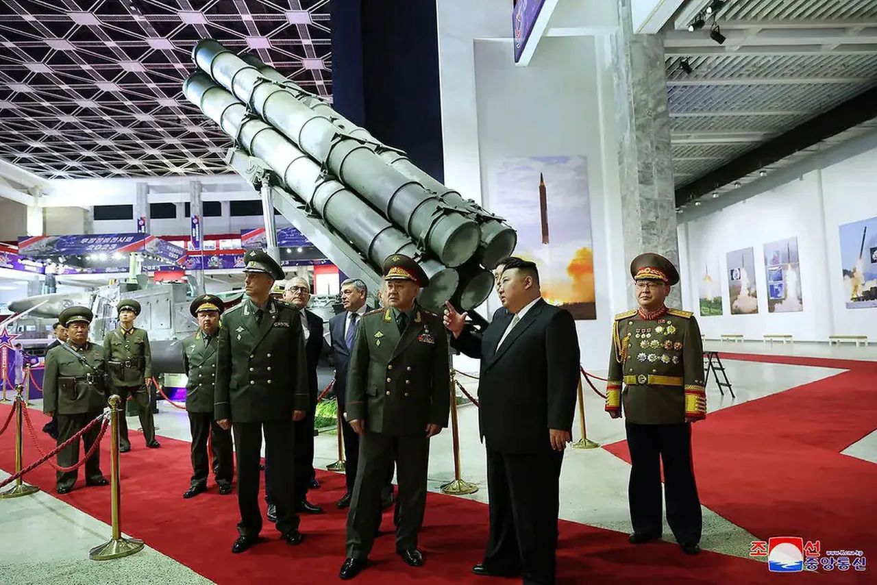 Russian and North Korean politicians viewing weapons at an exhibition in Pyongyang.