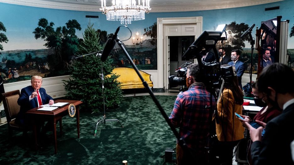 Donald Trump pozuje przy malutkim biurku