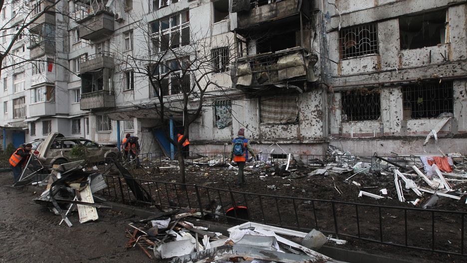 Municipal workers put the debris into the bucket of a backhoe loader outside a nine-storey apartment block damaged by a Russian drone attack in Dnipro, Ukraine, on November 23, 2025. Overnight, Russian forces launch a large-scale attack on the city, igniting balconies of a nine-storey residential building and damaging the premises of a private house. Six cars are also damaged in the strike. Fifteen people require medical assistance. Three remain hospitalized: women aged 52 and 64, and a 48-year-old man. One suffers from poisoning caused by combustion products, while the others sustain head injuries and lacerations. Doctors describe their condition as moderate. The remaining victims, including an 11-year-old girl, recover at home. (Photo by Mykola Miakshykov/Ukrinform/NurPhoto via Getty Images) NO USE RUSSIA. NO USE BELARUS. (Photo by Ukrinform/NurPhoto via Getty Images)