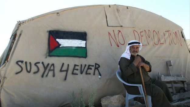 Mieszkaniec Susji przed swoim namiotem