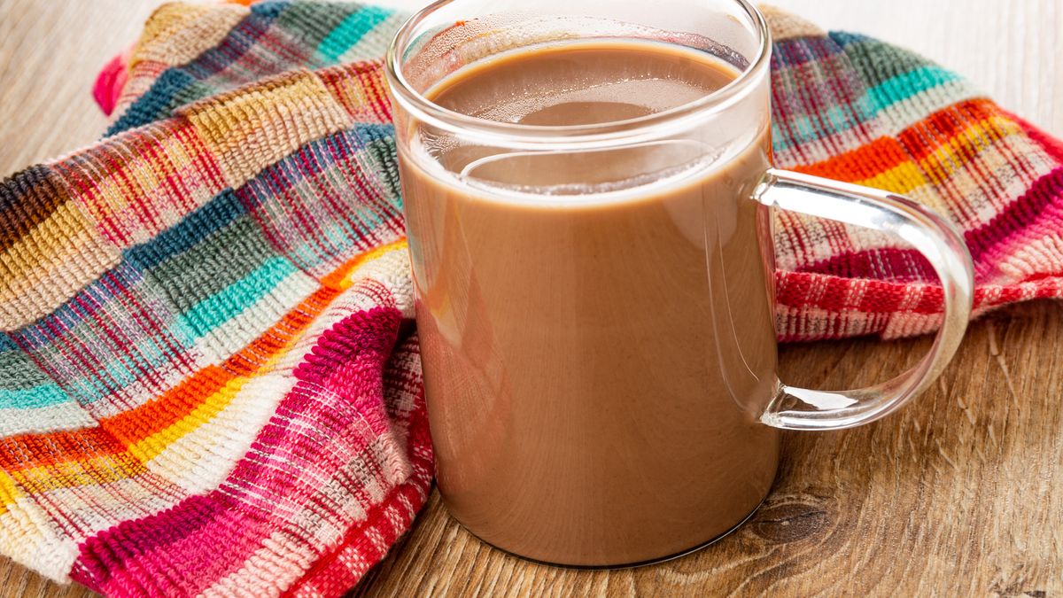 Napkin, cocoa with milk in transparent cup on wooden tableCheckered napkin, cocoa with milk in transparent glass cup on wooden tableEugeneTomeev