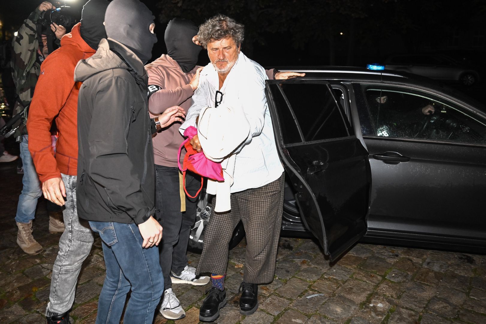 Wrocław, 03.10.2024. Były poseł Janusz Palikot (P) doprowadzany przez funkcjonariuszy CBA do Dolnośląskiego Wydziału Zamiejscowego Departamentu do Spraw Przestępczości Zorganizowanej i Korupcji we Wrocławiu, 3 bm. Janusz Palikot, Przemysław B. i Zbigniew B., których zatrzymało CBA w Lublinie i w Biłgoraju mają usłyszeć zarzuty. Sprawa dot. doprowadzenia do niekorzystnego rozporządzenia mieniem kilku tysięcy osób na ok. 70 mln zł. (mr) PAP/Maciej Kulczyński ***Do tego materiału zdjęciowego dostępna jest również depesza w systemie CSI, pt.: Były poseł Janusz Palikot przewożony do prokuratury we Wrocławiu***