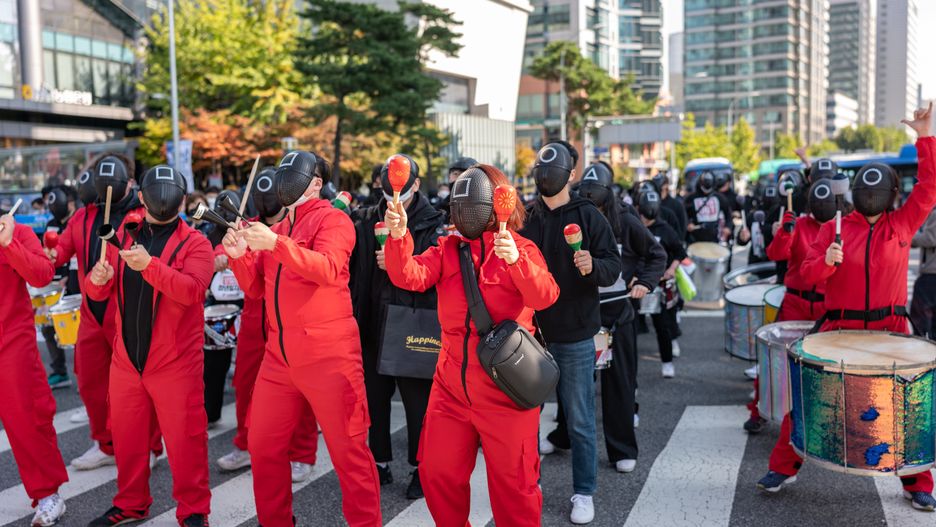 Members of the Korean Confederation of Trade Unions wear masks costumed in the Netflix series Squid Game for a march to Seoul City hall during a rally against the government's labor policy on October 20, 2021 in Seoul, South Korea. Thousands of union members hold a massive rally in Seoul as an one-day strike aimed at bringing labor issues to the next presidential election in 2022. (Photo by Chris Jung/NurPhoto via Getty Images)