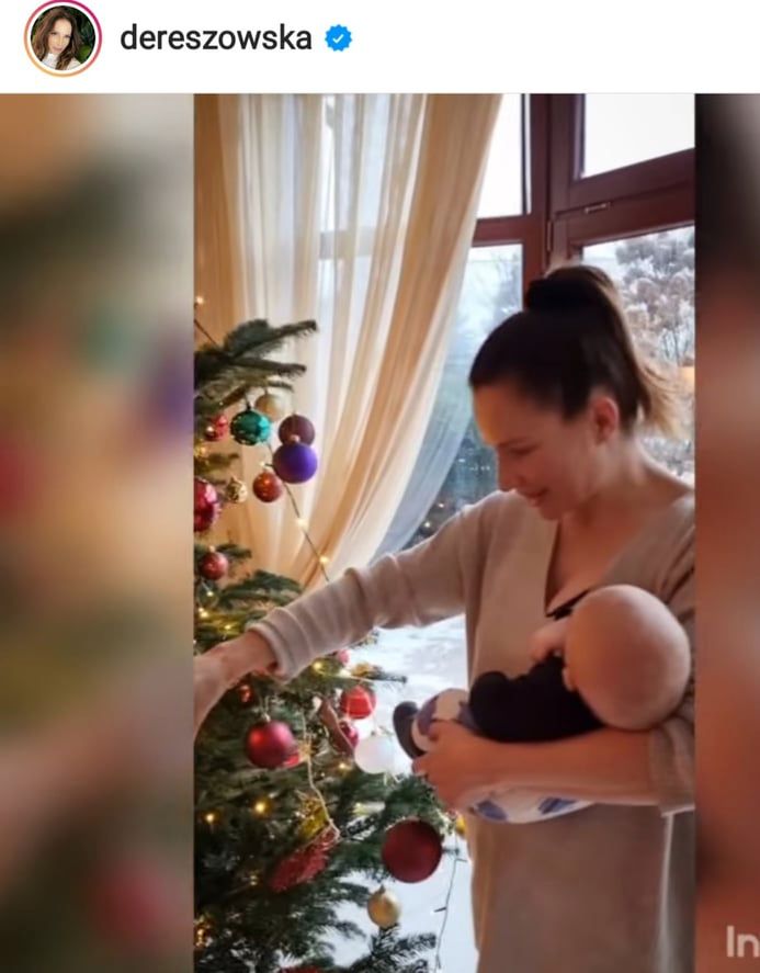 Anna Dereszowska z synkiem na rękach stroi choinkę