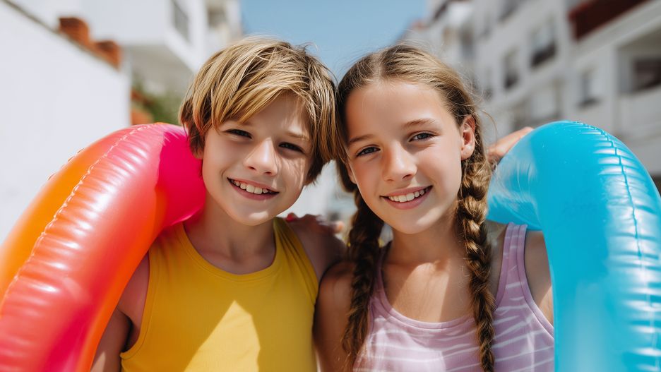 children, kids, summer, swimring, inflatable, outdoors, sunshine, happy, smiling, friendship, boy, girl, casual, vacation, holiday, leisure, fun, playful, youth, childhood, bright, warm, casualwear, blue, pink, yellow, striped, hair, braid, portrait, closeup, cheerful, joyful, relaxation, sun, sunlight, summerwear, carefreeness, bonding, togetherness, happiness, lifestyle