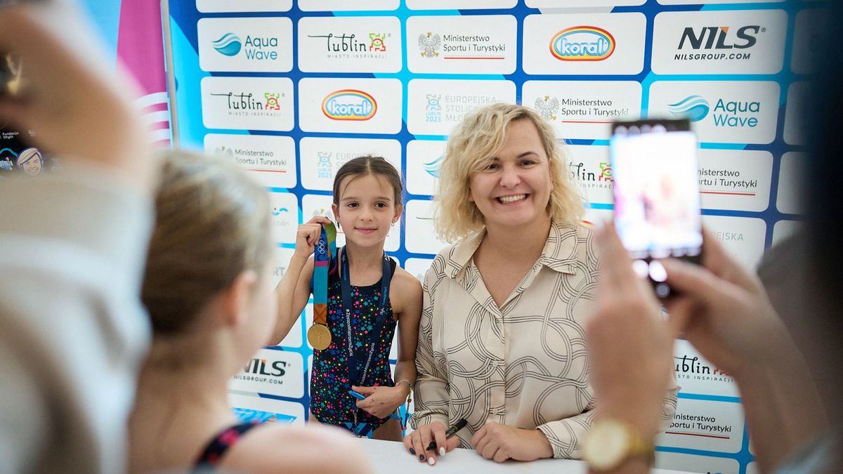 Zdjęcie okładkowe artykułu: Materiały prasowe / Otylia Swim Cup / Rafał Oleksiewicz / Na zdjęciu: Otylia Jędrzejczak i jej złoty medal igrzysk olimpijskich prezentowany przez jedną z uczestniczek imprezy w Lublinie