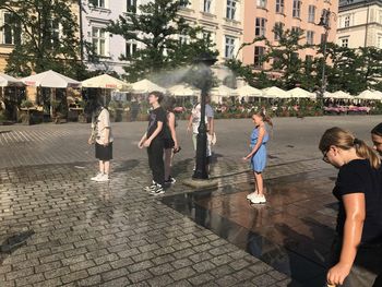 Kraków: Upał rozlewa się po mieście. Zraszacz na Rynku Głównym przyciąga spragnionych ochłody