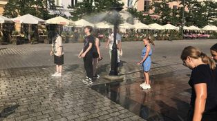Kraków: Upał rozlewa się po mieście. Zraszacz na Rynku Głównym przyciąga spragnionych ochłody
