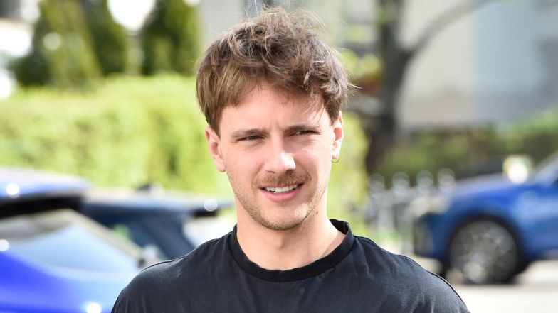 Maciej Musiał pręży nagą klatę, pozując w jeansowej spódniczce