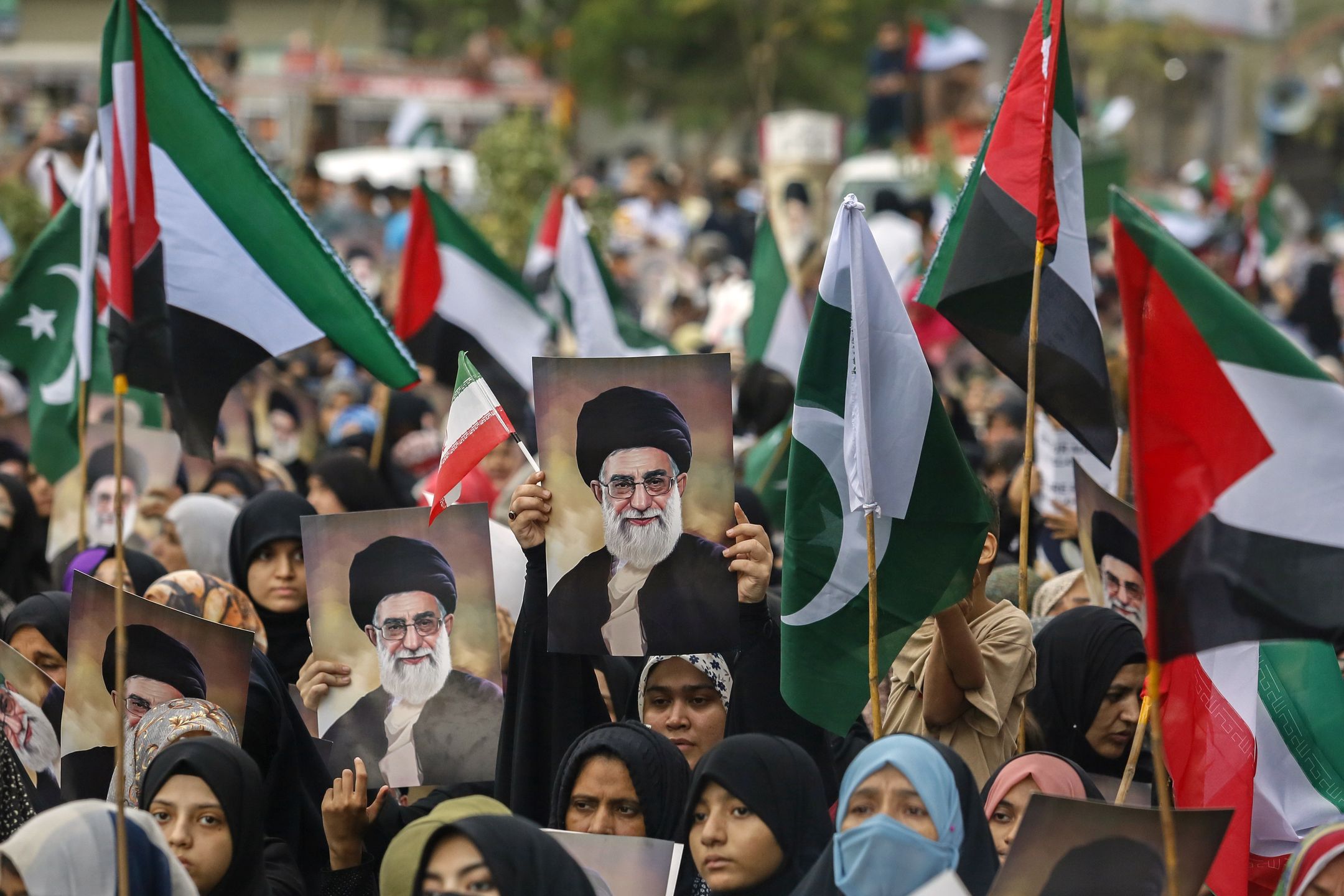 Protesters hold portraits of Iran's Supreme Leader Ayatollah Ali Khamenei along with Pakistani, Palestinian and Iranian flags during a demonstration against the US and Israel in Karachi, Pakistan, on Sunday, June 22, 2025. The unprecedented US airstrikes on Iran have set traders and governments worldwide on edge, as the Islamic Republic warns of retaliation and Israel shows no sign of letting up in its assault. Photographer: Asim Hafeez/Bloomberg via Getty Images
