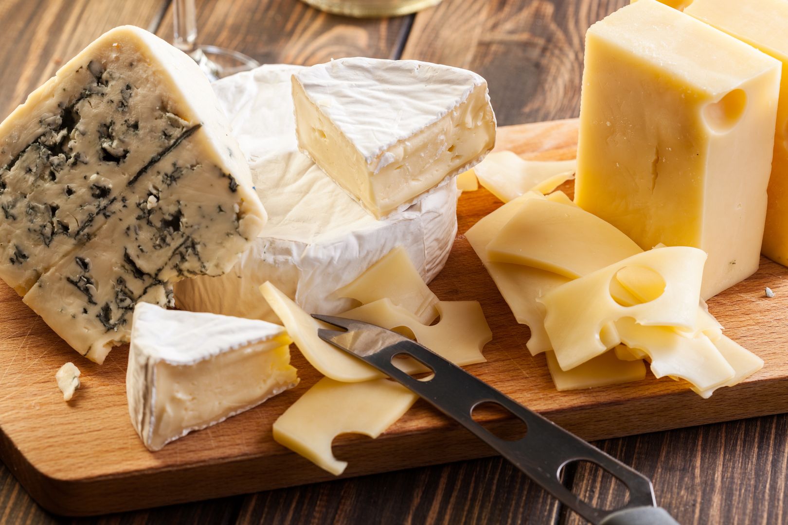 Set of different cheeses on a chopping boardcheeses, board, cutting, wooden, assorted, food, green, yellow, , horizontal, cheeses, board, cutting, wooden, assorted, food, green, yellow, cuisine, french, italian, slice, gourmet, meal, lunch, product, dairy, background, red, cut, table, closeup, appetizer, fruit, nobody, wine, glass, knife, horizontal