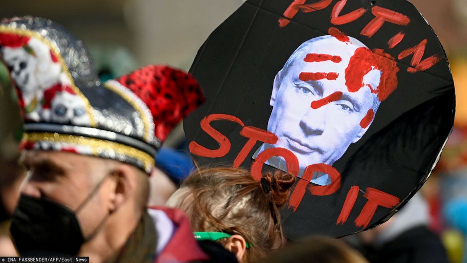 TemporaryA reveller holds a placard depicting the Russian President and reading "Putin stop it" during a peace march titled "Freedom for Ukraine" replacing the traditional Rose Monday carnival street parade in Cologne, western Germany, on February 28, 2022. (Photo by Ina Fassbender / AFP)INA FASSBENDER