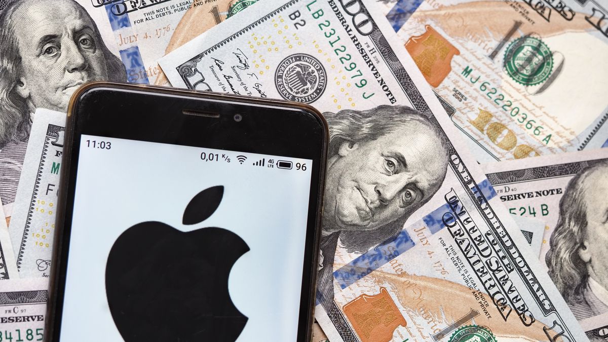 UKRAINE - 2020/09/04: In this photo illustration an Apple Inc. logo seen displayed on a smartphone with 100 dollar bills in the background. (Photo Illustration by Igor Golovniov/SOPA Images/LightRocket via Getty Images)