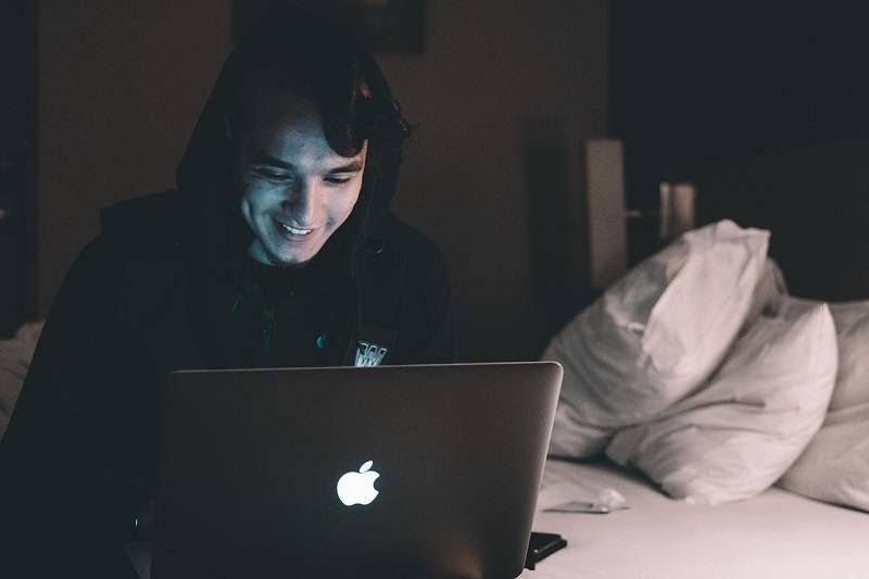 chłopak przed laptopem apple