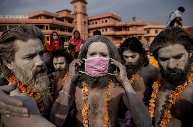 12.04.2021 r., Indie. Naga Sadhu, czyli hinduski przewodnik religijny, zakłada maseczkę ochronną tuż przed procesją wzdłuż Gangesu podczas święta Shahi Snan.