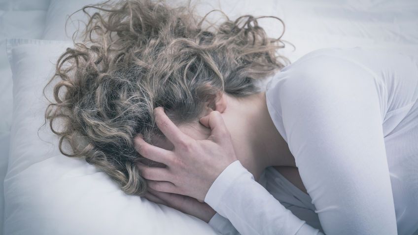 Zrozpaczona kobieta obejmująca twarz