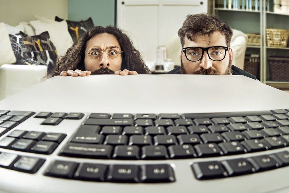 Zdjęcie dwóch geeków patrzących na klawiaturę pochodzi z serwisu Shutterstock