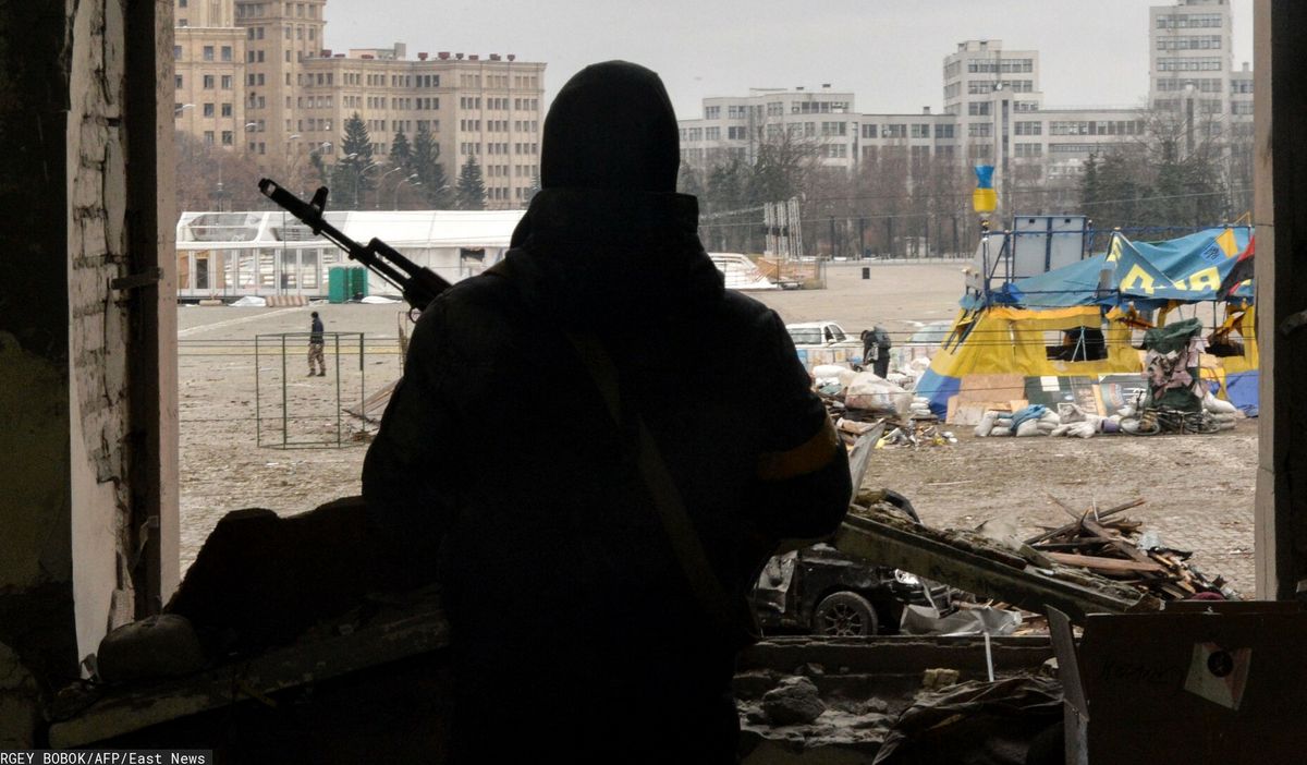 Wojna w Ukrainie. Na zdjęciu ukraiński żołnierz obserwujący plac przed zniszczonym ratuszem w Charkowie. 1 marca 2022 r. 