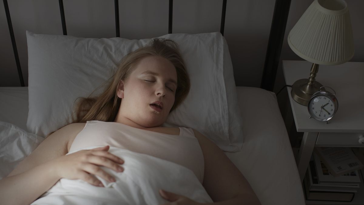 Young woman asleep in bedYoung woman asleep in bed.Science Photo Libraryhorizontal, horizontal image, one person, female, woman, 20-24 years, 20s, young woman, one young woman only, indoors, inside, eyes closed, lying down, asleep, sleeping, bed, bedroom, high angle view, high angle, overweight, obese, obesity, sleep