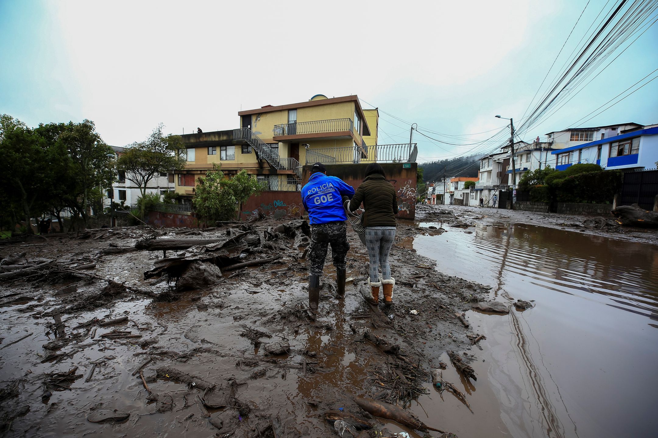 epa09721288 Police personnel try to remove a fallen tree due to the mudslide that occurred on 31 January, which affected some neighborhoods in the west of the Ecuadorian capital and caused at least 18 fatalities, as reported by the authorities in Quito, Ecuador, 01 February 2022. The number of people who died on 31 January rose to 18 after a flood that affected several neighborhoods in the west of the Ecuadorian capital, a city that was hit by a heavy downpour, with record rainfall, according to authorities.  EPA/Jose Jacome 
Dostawca: PAP/EPA.