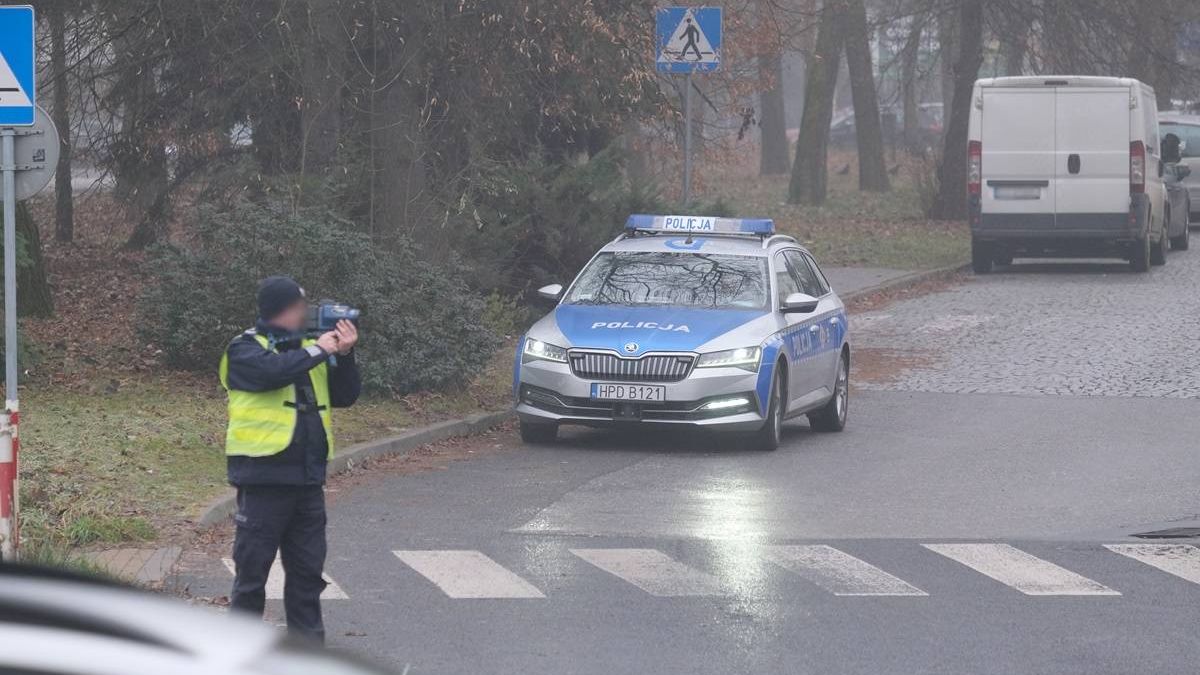 Policjant dokonujący kontroli prędkości nadjeżdżających pojazdów na ul. Mełgiewskiej