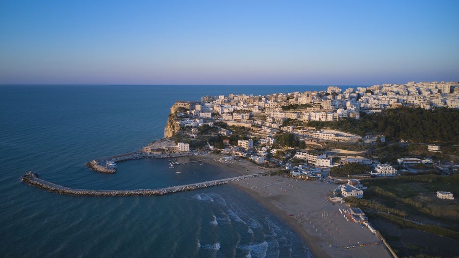 An aerial view shows the coastal town of Peschici, located on the Adriatic Sea in Italy, on July 8, 2020. This drone shot highlights the town's historic architecture and coastal landscape on the Gargano Peninsula. (Photo by Matteo Della Torre/NurPhoto via Getty Images)