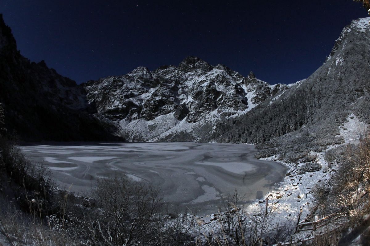 Zimowy krajobraz podczas pełni księżyca w rejonie Morskiego Oka w Tatrach 1 grudnia 2020 roku