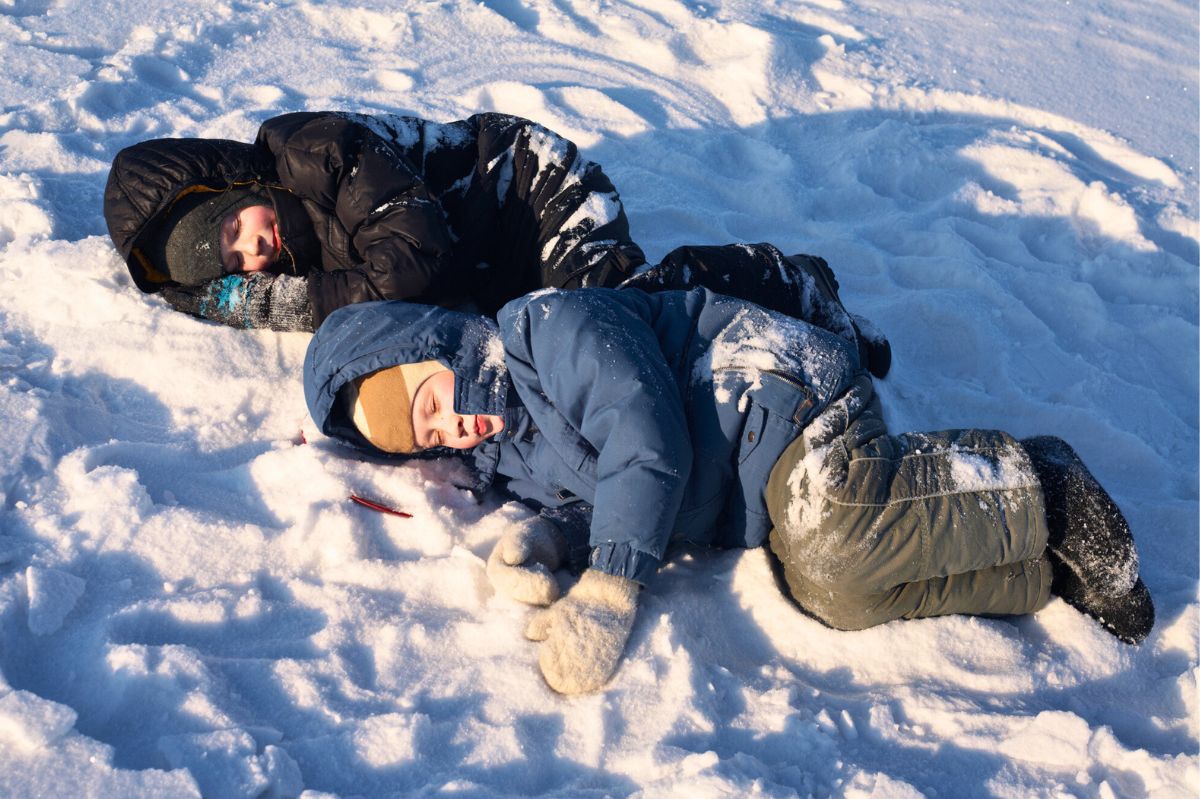 Dzieci leżą na śniegu