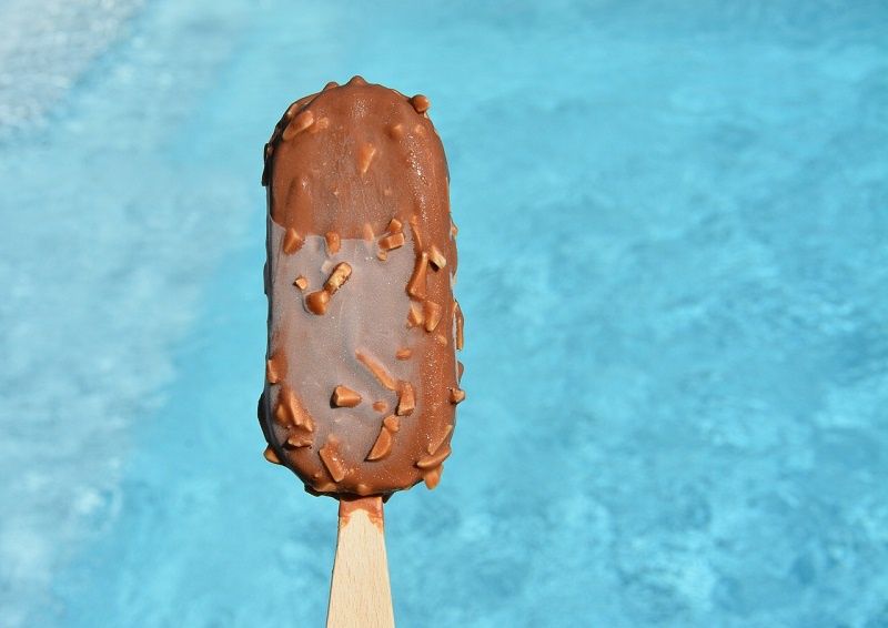 lody na patyku na tle basenu z woda
