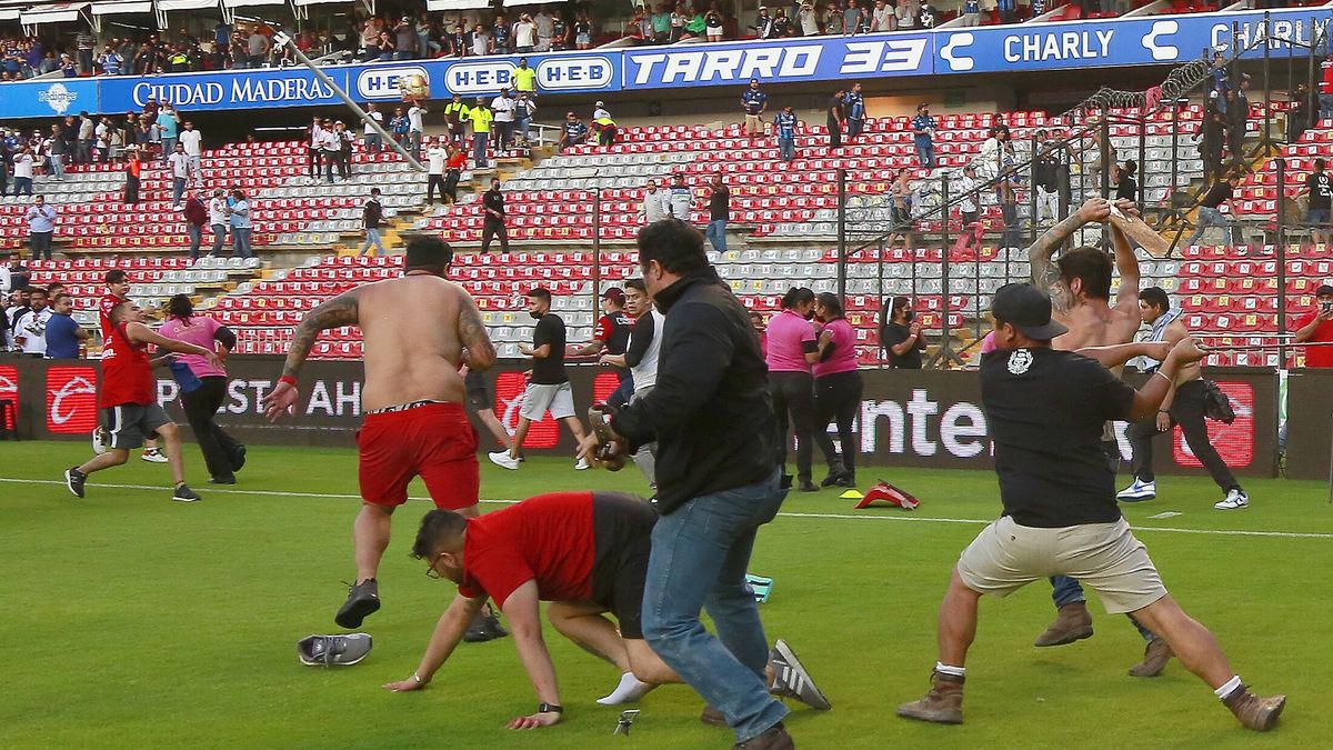 epa09804872 Queretaro and Atlas fans clash and ended up invading the field, during a game corresponding to matchday 9 of the Torneo Clausura 2022 of the Mexican Soccer League MX at the Corregidora stadium in the city of Queretaro, Mexico, 05 March 2022. At least 22 people have been injured, including two critically.  EPA/Enrique Contla Dostawca: PAP/EPA.